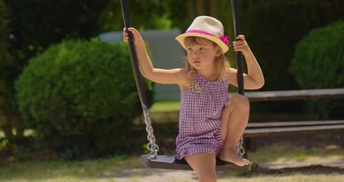 Little Girl is Swinging on a Swing Amusement Park Dream Concept Happy Girl in Hat Swinging on Swing