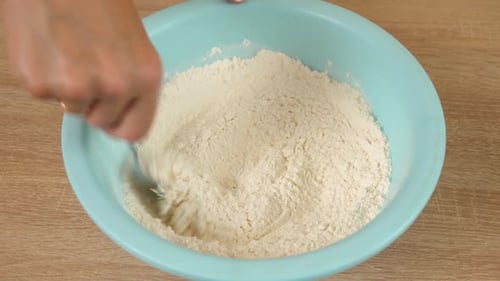 Mixing Flour in Blue Bowl with Metal Spoon