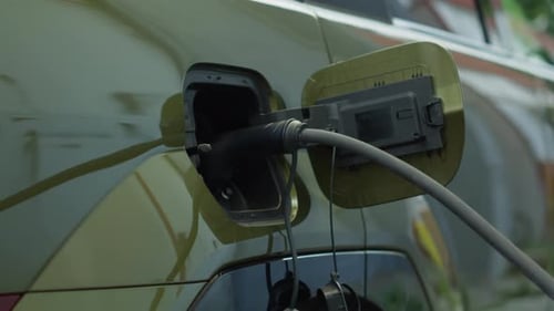 Close Up of Electric Cable Attached to EV Car Charging Port to Recharge Battery