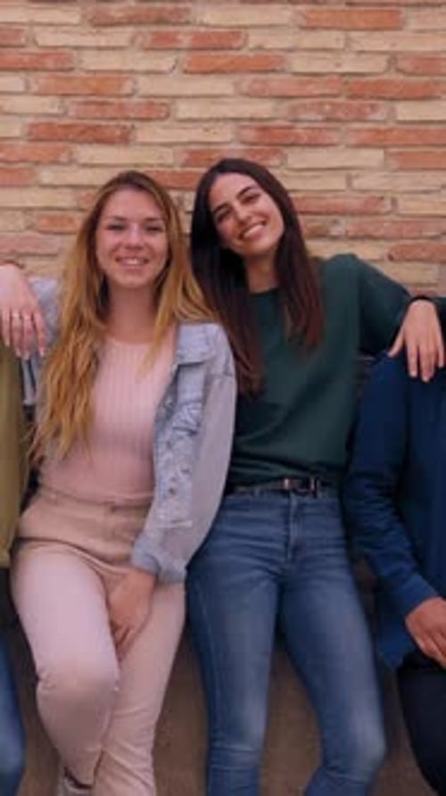 Three Happy Friends Leaning Against a Brick Wall