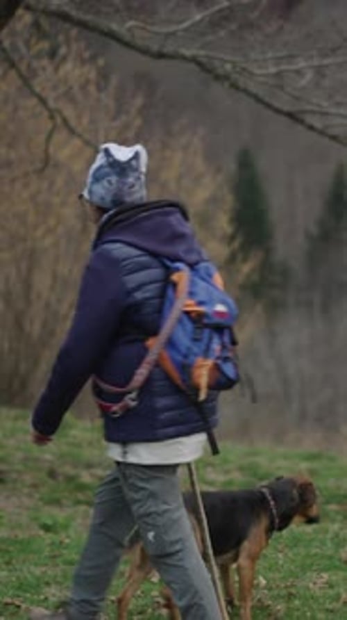 Adult Walking with Dog in Grassy Rural Field
