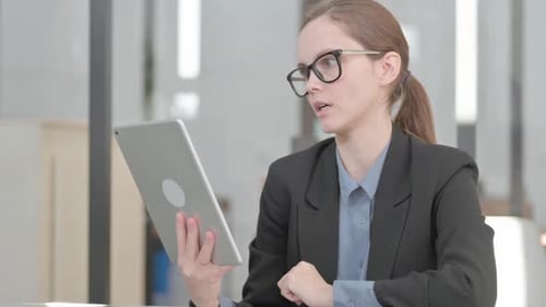 Woman Video Conferencing on Tablet in Modern Office