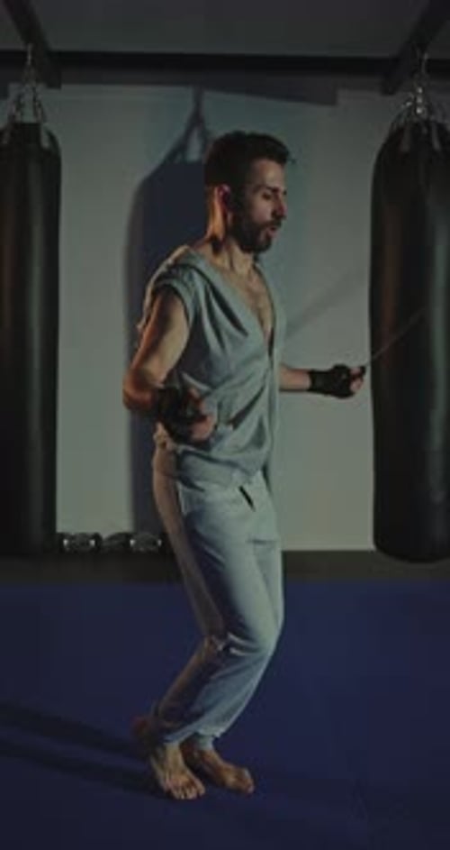 Muscular Man Cardio Workout with Jump Rope in Sport Club