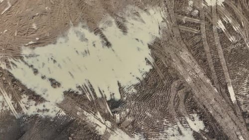 Aerial view of muddy ground with tire tracks