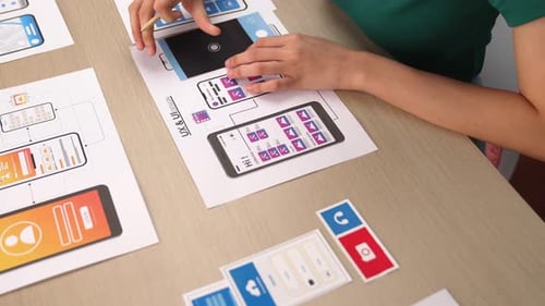 Woman designs mobile app at a table