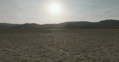 a large flat desert with mountains in the background