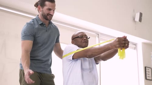 Man with Physical Therapist Doing Resistance Band Exercises