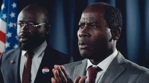 Man Giving a Speech Next to Supporter