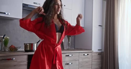 Woman Dancing in Red Robe in Modern Kitchen
