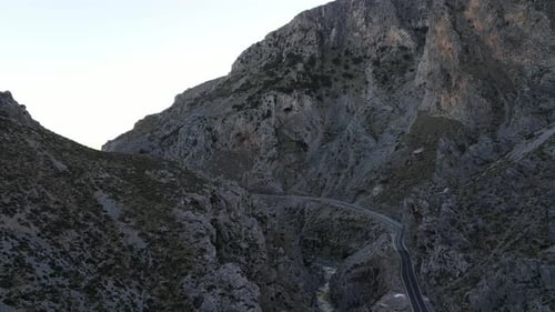 Drone flying above serpentine road in rocky mountain Koutaliotiko gorge. Mountain cliffs
