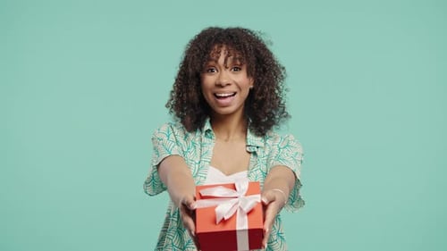 Smiling Woman Offers Gift on Blue Background