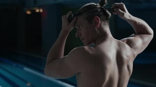 Caucasian Man Putting on Swimming Goggles by Pool