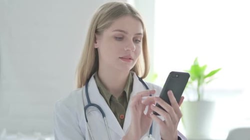 Female Doctor Using Smartphone in Hospital Office