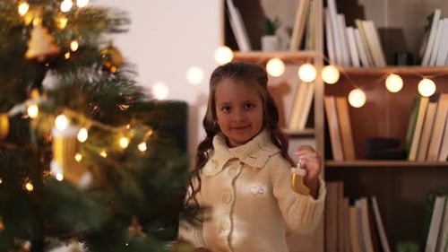 Child Smiling with Christmas Ornament