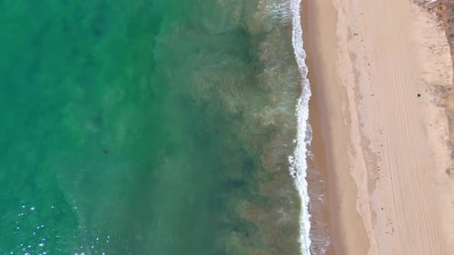 Beautiful turquoise water of the sea rolls the waves to the shore.