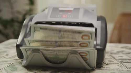 Money Counter Counts Stack of Hundred Dollar Bills