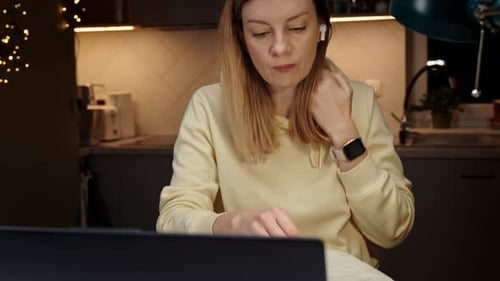 Mulher trabalhando em casa no local de trabalho à noite usando laptop