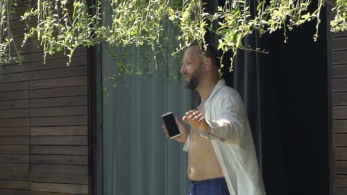 Young Man Listening to Music and Dancing in Garden Adult