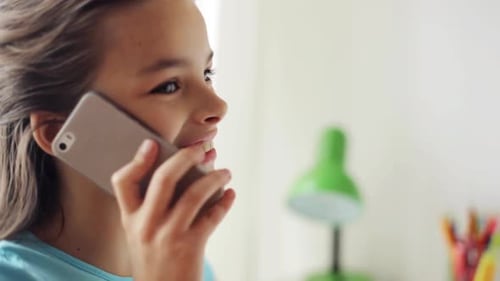 Smiling Girl Chatting on Smartphone Indoors