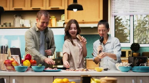Tiempo de cocinar en familia en la cocina con karaoke y divertidos movimientos de baile