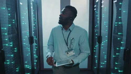 Man with tablet in data center server room