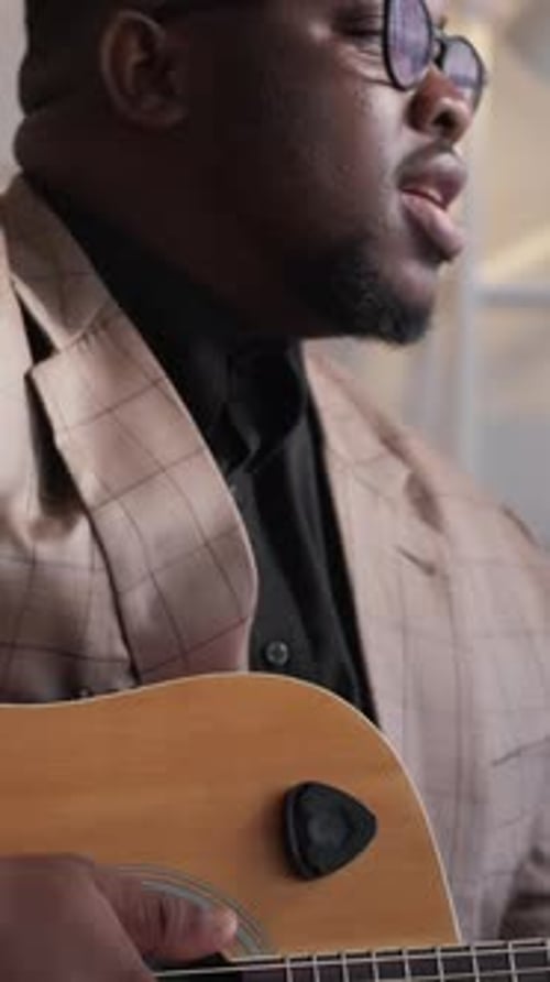 Adult Man Plays Guitar and Sings Indoors