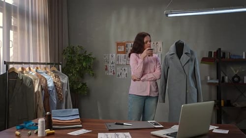 Junge erwachsene Geschäftsfrau verbringt Zeit im Büro, Modedesignerin trinkt Kaffee und schaut
