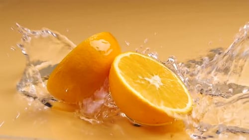 Super Slow Motion Shot of Flying Fresh Orange Slices and Water Splash