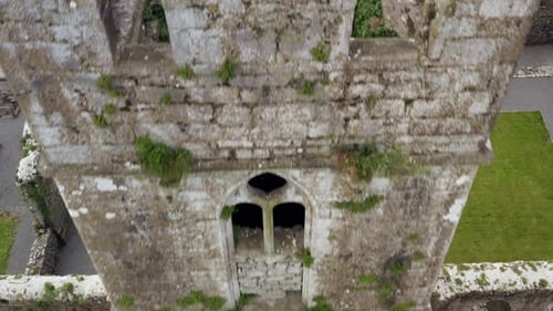 Claregalway Friary tower at center of aerial drone pulling back over stone remnants