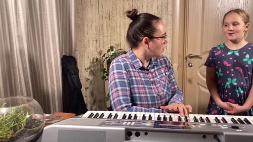 Woman and Child Sing and Play Electronic Piano