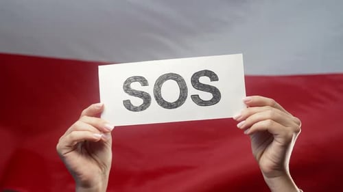 Female Hands with SOS Alarm Emergency Card on Polish National Flag Background Poland Labor