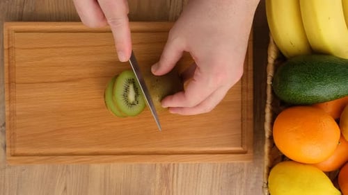 Top View Of Cutting Kiwi Fruit On The Kitchen Table