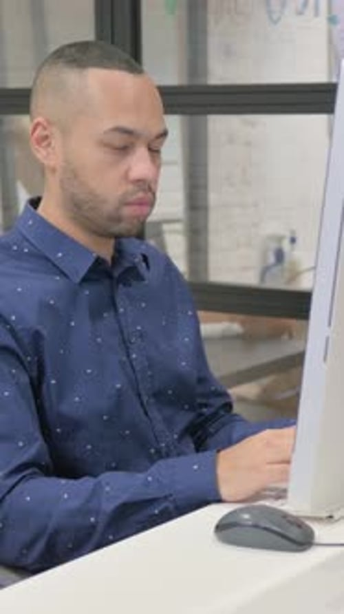 Hispanic Businessman Smiling at Camera while Working on Desktop in Office, vertical video