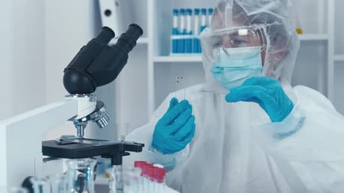 A Scientist in the Laboratory Examines the Microcosm Under a Microscope Collecting Data for Indepth