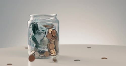Glass Jar Filling With Coins and Money