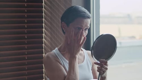 Woman Applies Skincare in Natural Light at Home