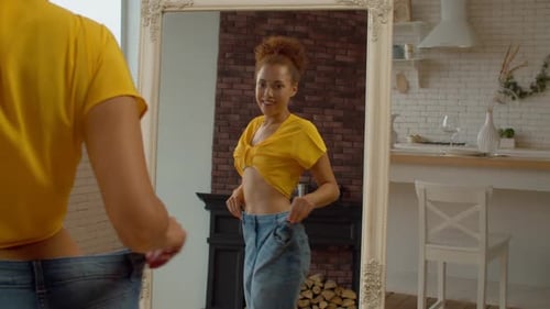 Woman Shows Weight Loss in Mirror at Home