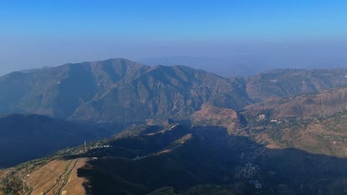 view of sprawling hillside area with terraced fields, lush greenery, and serene mountain slopes