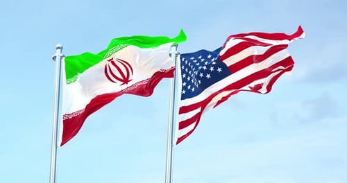 Iran and USA Flags Waving in Wind Against Blue Sky