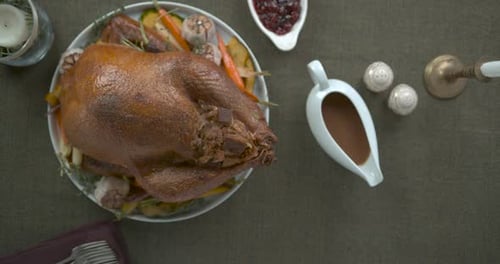 Table de Thanksgiving raffinée avec dinde farcie, sauce, purée de pommes de terre, salade et gelée, sur un plat vert...