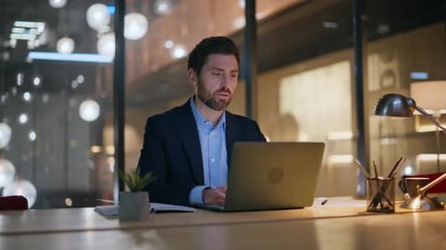Homme d'affaires barbu parlant à un collègue travaillant la nuit, espace de coworking, gros plan