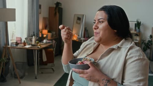 Young Adult Eats Bowl of Cereal at Home