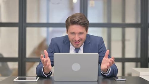 Man Working at Laptop Receives Good News