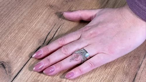 Hand Showing Jewelry Ring on Wood