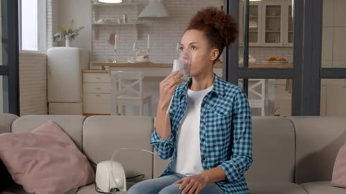 Woman Using Nebulizer at Home for Respiratory Treatment