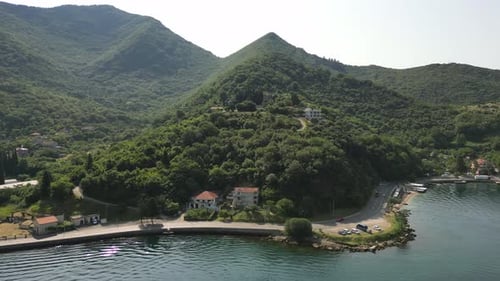Aerial View of the Coastal Road in the Bay of Kotor with Cars Driving Along It Against the Backdrop