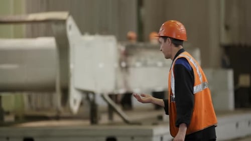 Man Gesturing at Metal Manufacturing Plant