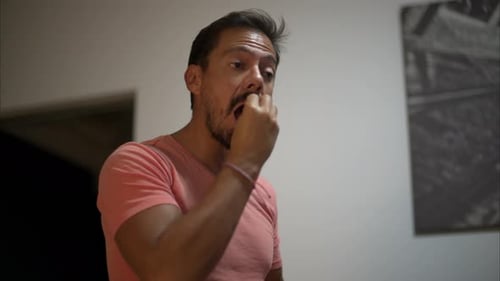 Zeitlupe eines lateinamerikanischen Mannes mit Bart, der ein Spiel spielt und so tut, als würde er essen und kauen, während er versucht
