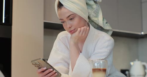 Woman Relaxes with Phone in Kitchen