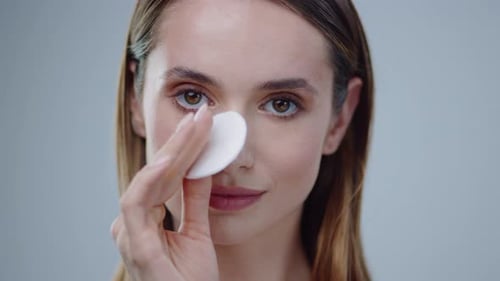 Woman Cleans Her Face With Cotton Pad